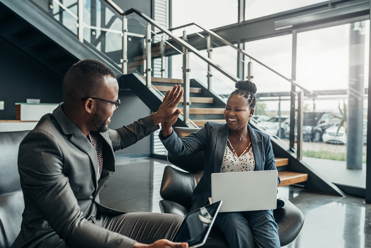 A business team celebrating a customer experience win with a high five
